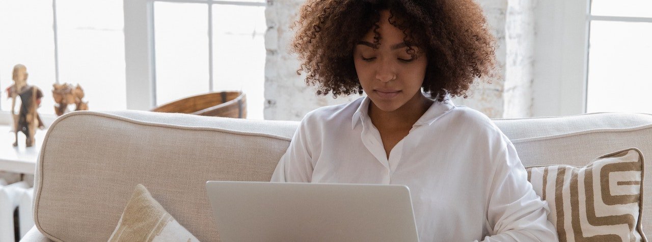 Woman sitting on couch with laptop