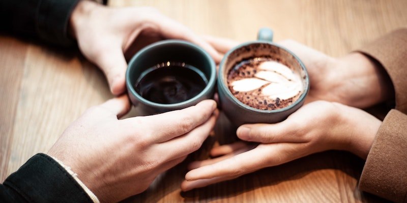 couple holding hands and coffee