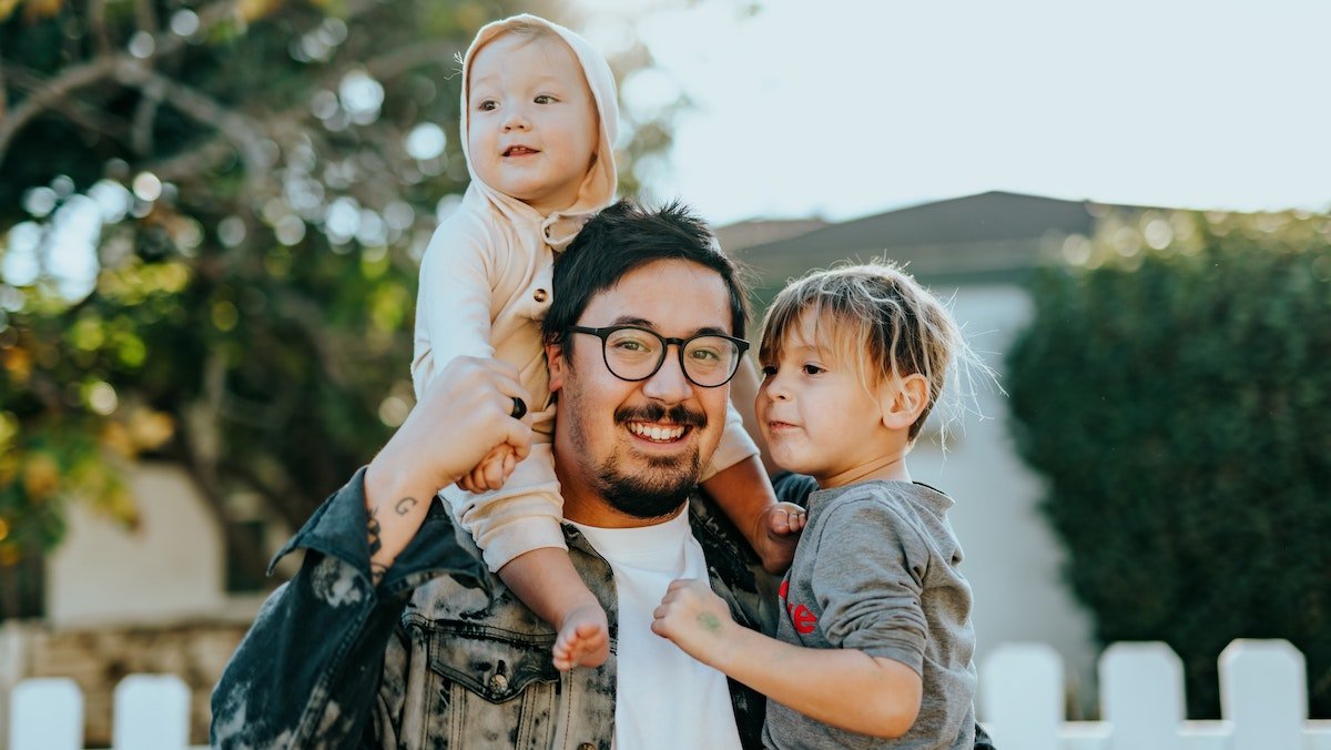 Dad with kids in front of house