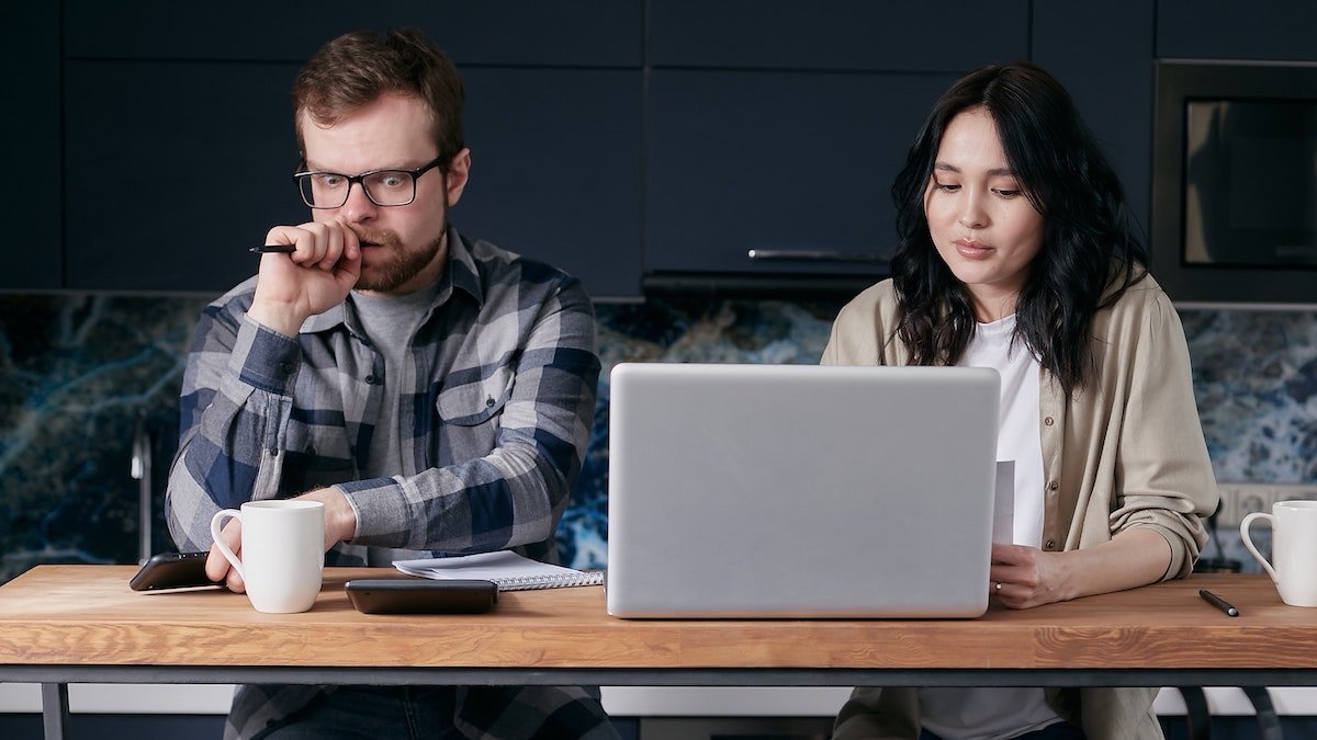 Couple by laptop thinking