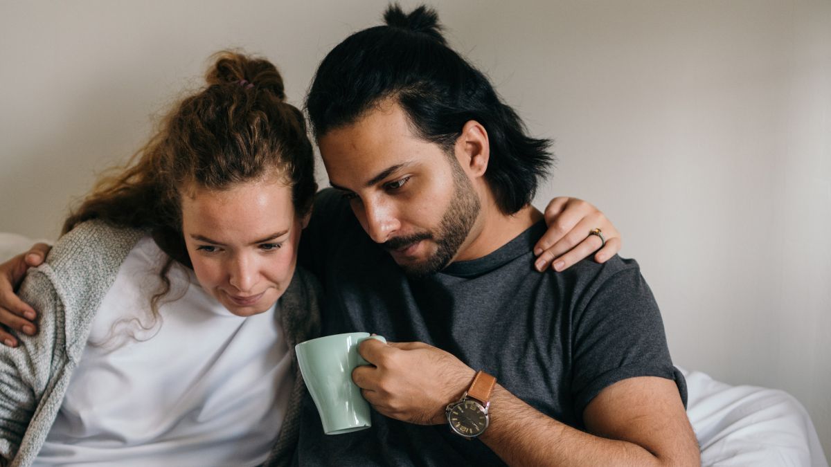 couple on couch looking at laptop