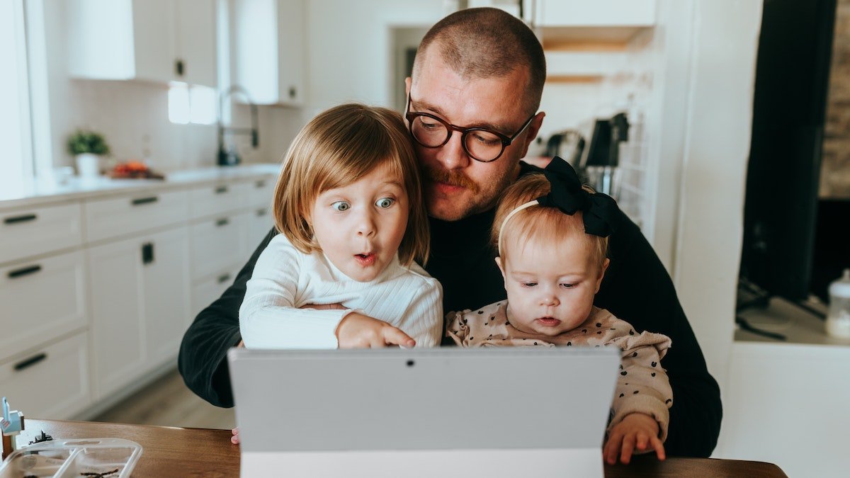 Dad checking computer with kids